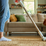 Woman,Is,Vacuuming,Floor,Of,Modern,Apartment,Living,Room,,Using