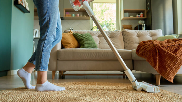 Woman,Is,Vacuuming,Floor,Of,Modern,Apartment,Living,Room,,Using