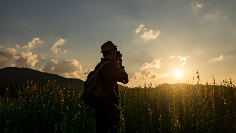 Silhouette of a young who like to travel and photographer, takin