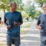 Two male friends running in the public park