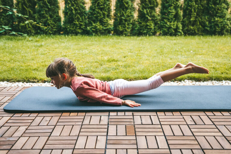Little,Girl,5-6,Years,Old,Lying,In,A,Locust,Pose,