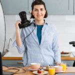 food photographer with camera working in kitchen
